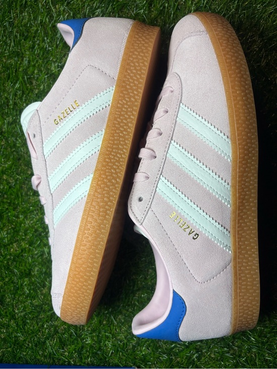 adidas Shoes - Adidas Gazelle Suede Sneakers in Light Pink with white Stripes and a blue heel.